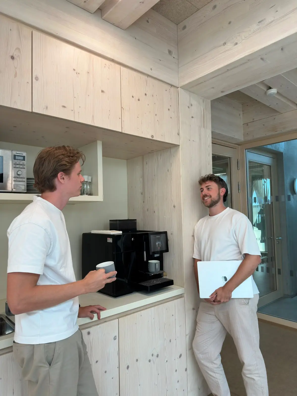 Zwei Teammitglieder von PANDADEV im Gespräch an der Kaffeemaschine