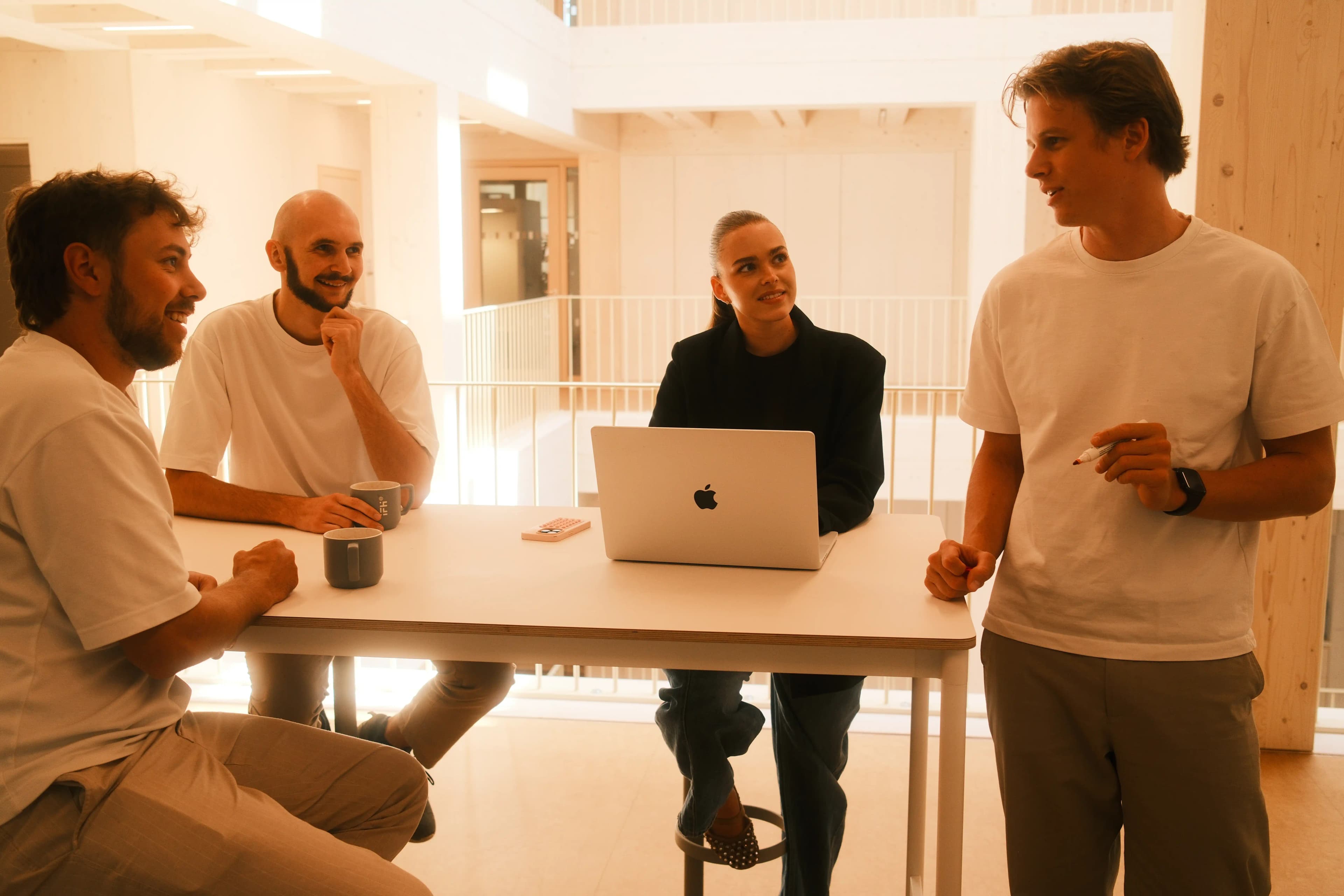 Das Entwicklerteam von P&A Development bespricht ein Softwareprojekt am Stehtisch