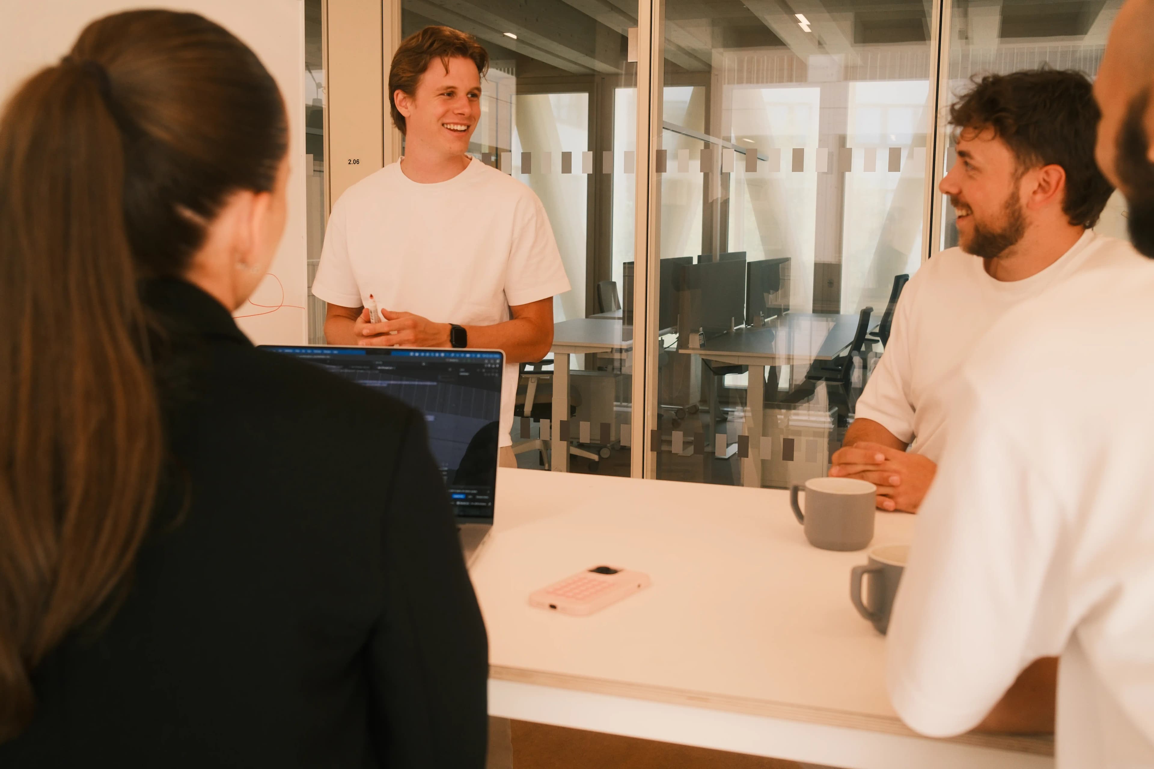Das Team von P&A Development diskutiert lachend Automatisierungs-Ideen am Whiteboard